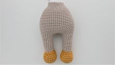 a crocheted stuffed animal with yellow feet