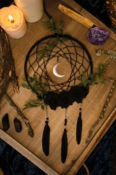 a wooden table topped with candles and other items on top of it, including a dream catcher