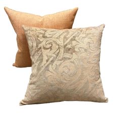 two pillows with decorative designs on them, one tan and the other light brown color