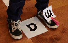 a person standing on top of a wooden floor next to a pair of shoes with the letter d on them