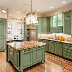 a large kitchen with green cabinets and marble counter tops