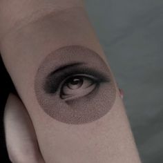 a woman's arm with an eye tattoo on it