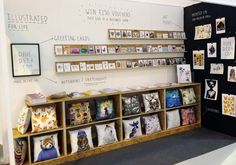 a display case filled with lots of cards and pictures next to a blackboard wall