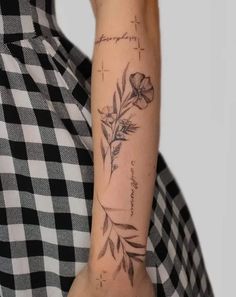 a woman's arm with a flower tattoo on the left side of her arm