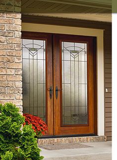 the front door to a house with two glass doors and brick pillars on either side