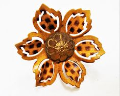 an animal print flower brooch on a white background