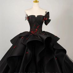 Elevate your wedding day with a touch of dramatic elegance in our Plus Size Gothic Ball Gown, a stunning tribute to gothic romance and sophisticated design. This gown is a symphony in black, crafted with luxurious fabrics that cascade into a full ballroom skirt, making every step you take a statement of grandeur. The off-shoulder neckline is adorned with exquisite black and red flowers, bringing a bold and beautiful contrast that captures the eye and ignites the imagination. These floral accents Black Wedding Dress With Sweep Train For Party, Black Floor-length Wedding Dress For Formal Occasion, Formal Floor-length Black Wedding Dress, Black Floor-length Wedding Dress With Fitted Bodice, Black Floor-length Formal Wedding Dress, Black Floor-length Wedding Dress For Party, Elegant Black Gown For Halloween, Black Ball Gown Wedding Dress For Debutante Ball, Elegant Black Halloween Gown