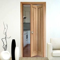 an open door leading to a kitchen and living room with white furniture in the background