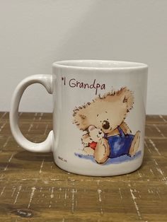 a white coffee mug with an image of a teddy bear and the words i grandpa on it