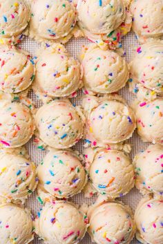 sprinkle covered cookies sitting on top of a table