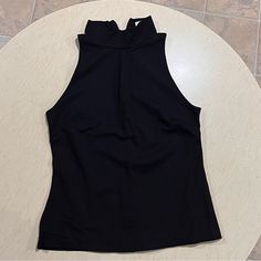 Washed But Never Used. Nice Thick Material. Mock Neck And Sleeveless. Black Stretch Halter Top Vest, Black Stretch Halter Top, Casual Black High Neck Tank Top, Casual High Neck Black Tank Top, Black High Neck Casual Tank Top, Spring Black High Neck Halter Top, Black Halter Neck Vest For Spring, Black High Neck Halter Top For Spring, Chic Black High Neck Halter Top