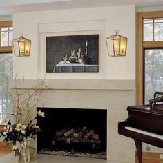 a living room filled with furniture and a piano in front of a fire place surrounded by windows