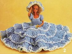 a crocheted doll is wearing a blue dress