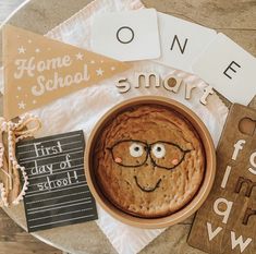 a cookie in a bowl with glasses on top of it next to some cards and other items