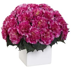 pink carnations in a white square vase on a white tablecloth with green leaves