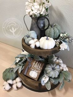 three tiered trays with flowers, pumpkins and other fall decorations on them