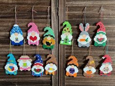 cross stitch christmas ornaments hanging on a wooden wall