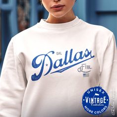 This Dallas Cowboys Crewneck Sweatshirt would make the perfect gift for your diehard Dallas football fan.  This vintage collection features a Dallas retro style typography design and team colors USA flag.  Perfect birthday, Christmas or anytime gift for the hardcore Dallas football fan in your life! Ideal for any situation, a unisex heavy blend crewneck sweatshirt is pure comfort. These garments are made from polyester and cotton. This combination helps designs come out looking fresh and beautiful. The collar is ribbed knit, so it retains its shape even after washing. * 50% cotton, 50% polyester * Medium-heavy fabric (8.0 oz/yd² (271.25 g/m²) * Loose fit * Sewn-in label * Runs true to size * Tear away label * Color of products may appear different on various monitors * Machine wash inside Throwback Fan Merchandise Cotton Sweatshirt, Throwback Cotton Sweatshirt For Fan Merchandise, White Throwback Sweatshirt With Letter Print, Pre-shrunk Cotton Throwback Sweatshirt, Fan Merchandise Crew Neck Sweatshirt With Lettering, Varsity Style Tops With Lettering For Fan Merchandise, Cotton Sweatshirt With Letter Print For Fans, Dallas Cowboys Football, Cowboys Football