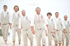 a group of men in suits and ties walking on the beach