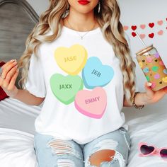 This cute sweetheart design is customizable with any words and perfect for the month of love! Wear it for Valentine's Day or just to show the things or people you love! We can add as many hearts as you would like. Show off your favorite things with this conversation heart shirt!  We have sweatshirts (Gildan 18000) and t-shirts (Bella+Canva) available in adult sizes. Youth, toddler, and baby sizes are also available, but brands will vary based on availability.  Direct to film transfers are used t Personalized White Tops For Valentine's Day, Customizable Crew Neck Tops For Valentine's Day, Personalized Short Sleeve Tops For Valentine's Day, Cute White T-shirt For Valentine's Day, Cute White Valentine's Day T-shirt, Personalized White T-shirt For Valentine's Day, White Valentine's Day T-shirt With Name Print, Personalized Short Sleeve T-shirt For Valentine's Day, White T-shirt With Heart Graphic For Valentine's Day