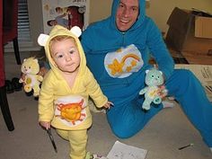 a man in a blue and yellow costume poses with a baby wearing a bear suit