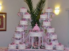 there is a very large cake tower on the table with many different types of cakes