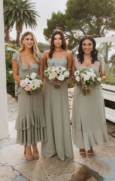 three bridesmaids in sage green dresses holding bouquets