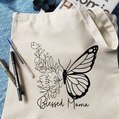 Flowers for mom with a butterfly she can keep and a Blesses Mama message. This bag measures 15x13x4 and it is made with 12oz. Heavy Duty Canvas. The design is made with Heat Transfer Vinyl. An amazing gift for mom for mother's day or any time. Great gift for  Mom Grandma Aunt Sister In-Laws Neighbor Friend and alo Graduates New moms Guest Bags Bridesmaids gifts Teacher Appreciation Eco-friendly, non-toxic, no more plastic bags, just one reusable, washable Heavy Duty 12oz. canvas tote bag. Great Painting On Tote Bags, Hand Painted Tote Bags Art, Tote Bags Painting, Picnic Crafts, Customized Tote Bags, Hand Painted Tote Bags, Painted Purses, Creative Tote Bag, Handpainted Tote