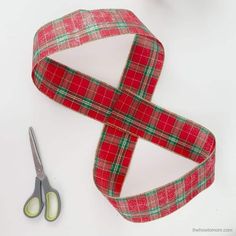 a red and green plaid ribbon next to scissors