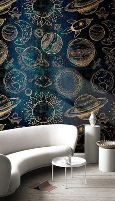 an artisticly designed living room with planets on the wall and white furniture in front