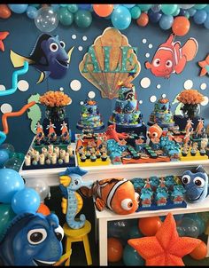 an under the sea themed birthday party with balloons, decorations and fish on it's table