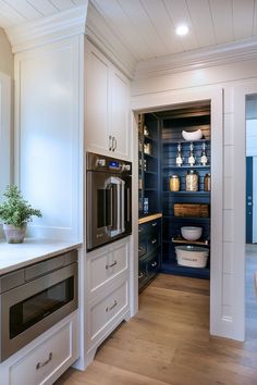 a kitchen with an oven, microwave and other items in the cupboards that are open