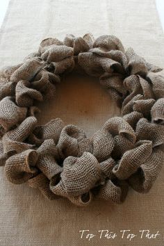 a burlocked wreath sitting on top of a linen tablecloth covered floor