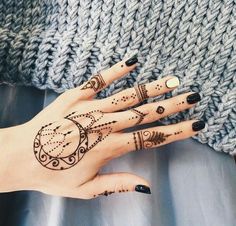 someone with henna on their hand is looking at the camera