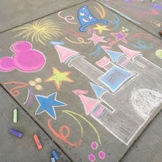 a sidewalk with chalk drawings and crayons on it