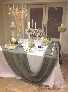 the table is set with candles and desserts for an elegant wedding or special event