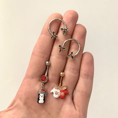 a person's hand holding four different types of rings in their palm, one with a snowman and the other with a dog