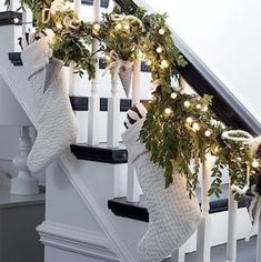 stockings hung on the banisters decorated with christmas lights and greenery, along with garland