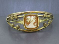 Beautiful antique cameo bracelet, not marked gold filled but tested and guaranteed.  Has light age related wear and patina.  Interesting clasp type, never seen it before but it works great.  Carved cameo looks great! Visit Ribbons Edge for more great pieces of vintage and antique jewelry!  All items added to your cart at Ribbons Edge will automatically combine shipping. To stay up to date with my newest offerings, follow me on IG @ RibbonsEdge Victorian Gold Bracelets With Cabochon, Vintage Yellow Gold Cabochon Bracelets, Antique Cabochon Bracelets For Wedding, Antique Gold Cabochon Bracelets, Gold Cameo Jewelry In Art Nouveau Style, Gold Art Nouveau Jewelry With Intaglio, Antique Oval Cameo Bracelet, Antique Gold Bracelets With Cabochon, Antique Gold Cameo Jewelry For Formal Occasions