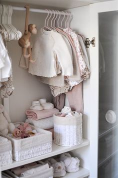 an organized closet with clothes and baby items on shelves, including blankets, diapers, socks and other things