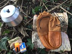 an oven mitt next to a tea kettle and some other items on the ground