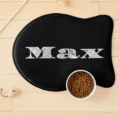 a black mat with the word msk next to a bowl of dry dog food