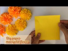 someone is making flowers out of yellow paper