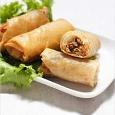 some food on a white plate with lettuce and meat in the wrapper