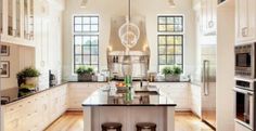 a large kitchen with white cabinets and wooden floors