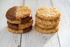 three cookies with chocolate frosting on top sitting on a white wooden table next to each other