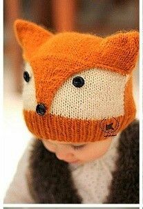 a little boy wearing a knitted hat with a fox design on the front and side