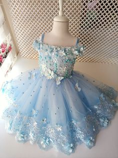 Our blue flower butterfly dress is made of tulle and satin fabrics; It is handcrafted with pearl and lace embroidery. It will be a great choice for your special days such as wedding birthday photo shoots. It is prepared in the dimensions and changes that you want completely personalized. You can choose it as a long dress or a short dress. An elegant tiara to match the dress is hand-made and sent as a gift. It is prepared from 1 year to 6 years old. Our quality is guaranteed.  if your baby is outside the standard sizes, please give the size; a-chest size b-waist size c- the length you want from the shoulder For orders up to 2 years old, shoes are also sent as a gift. The crown is prepared in the form of a dress. happy shopping Tulle Flower Dress, Butterfly Wing Dress, Elegant Tiara, Blue Butterfly Wings, Satin Fabrics, Wings Dress, Detailed Dress, Dress Baby Girl, Puffy Dresses