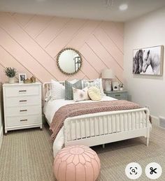 a bedroom with pink walls and white furniture