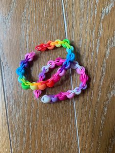 two different colored bracelets sitting on top of a wooden floor